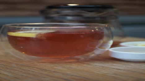 a cup of tea with lemon on a wooden table