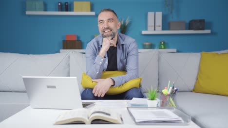 Man-starting-to-daydream-during-work-at-home.-He's-Laughing.