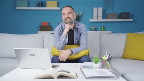 el hombre comienza a soñar despierto durante el trabajo en casa. se está riendo.