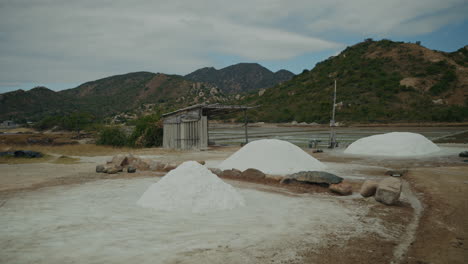 salt piles and evaporation ponds with mountains in the background