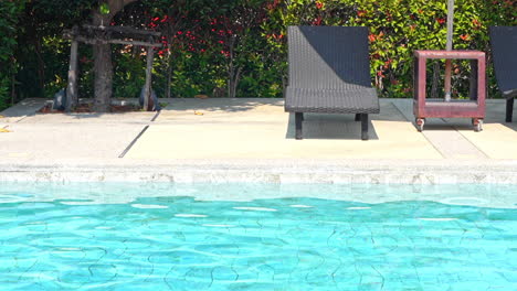 Una-Tumbona-De-Playa-Vacía-Se-Sienta-A-Lo-Largo-Del-Borde-De-Una-Piscina