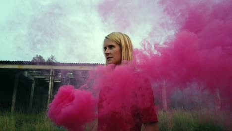 amazing slow motion cinematic shot: lonely sexy jung blond girl in red dress with a red smoke bomb walk in front tank hall ruins. foto video shoot on lost places in nature 1080, 24p by philipp marnitz