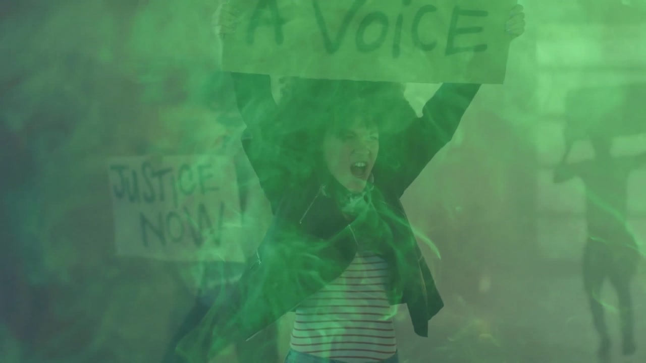 Green haze filling frame sparking woman holding Voice sign, leading social justice protest march
