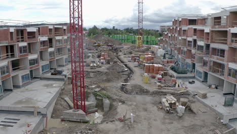 Construction-of-new-apartment-blocks,cranes,ditch,material,drone-shot