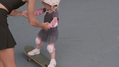 woman spending time with daughter in rollerblading park