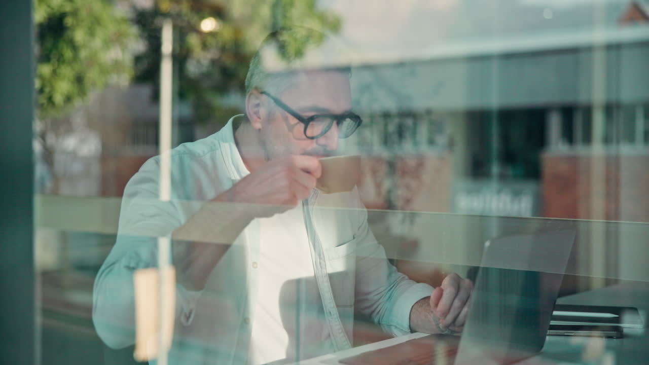 Man working on laptop at cafe with coffee