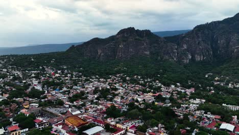 vista aérea volando sobre la ciudad de tepoztlan, hacia las montañas en el nublado méxico