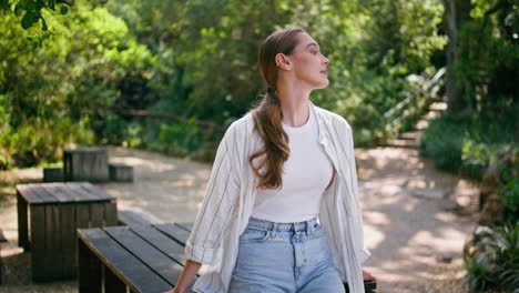 romantic model posing summer forest leaning on table. woman enjoy green nature