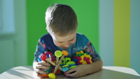 happy boy with toys. smiling little child with blue eyes holding many bright toys on the room background. happy childhood.