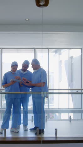 team of surgeons discussing over digital tablet