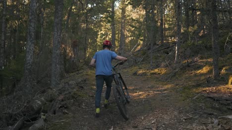 mountain biker going up a mountain with his bike ready for adventure texada island british columbia canada