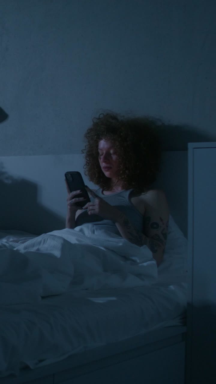 mujer usando el teléfono en la cama por la noche