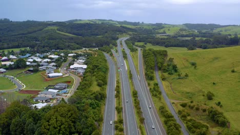 Sistema-De-Carriles-Locales-expresos-Con-Automóviles-Que-Pasan-Por-Verdes-Colinas-Y-Campos-Durante-El-Día-En-Byron-Bay,-Nsw,-Australia