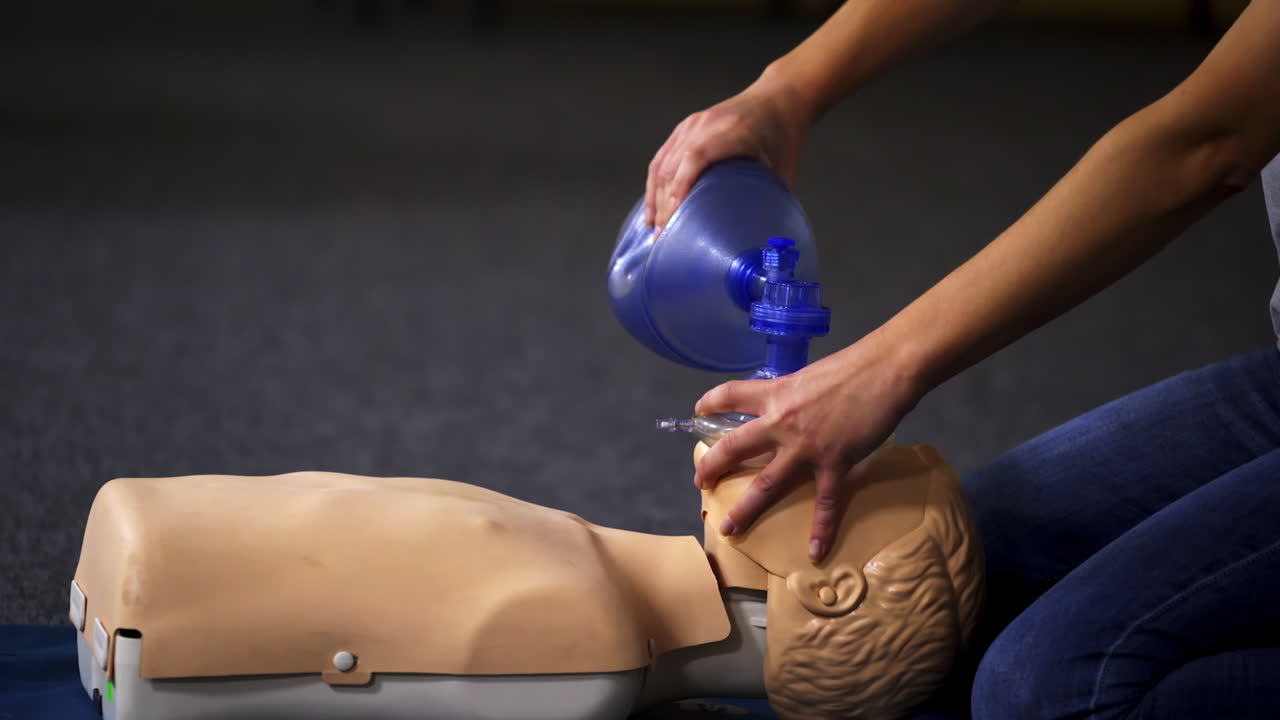 Teaching procedure on a dummy. Medical demonstration of resuscitation on a mannequin in training center. Instructor showing breathing exercise with medical apparatus.
