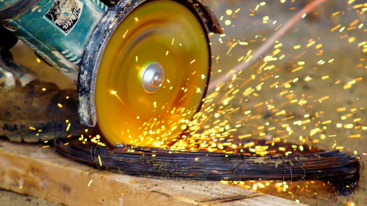 corte de alambre con sierra circular en ducha de chispas en el banco de trabajo