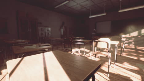 view to classroom with tables and small blackboard and grungy walls