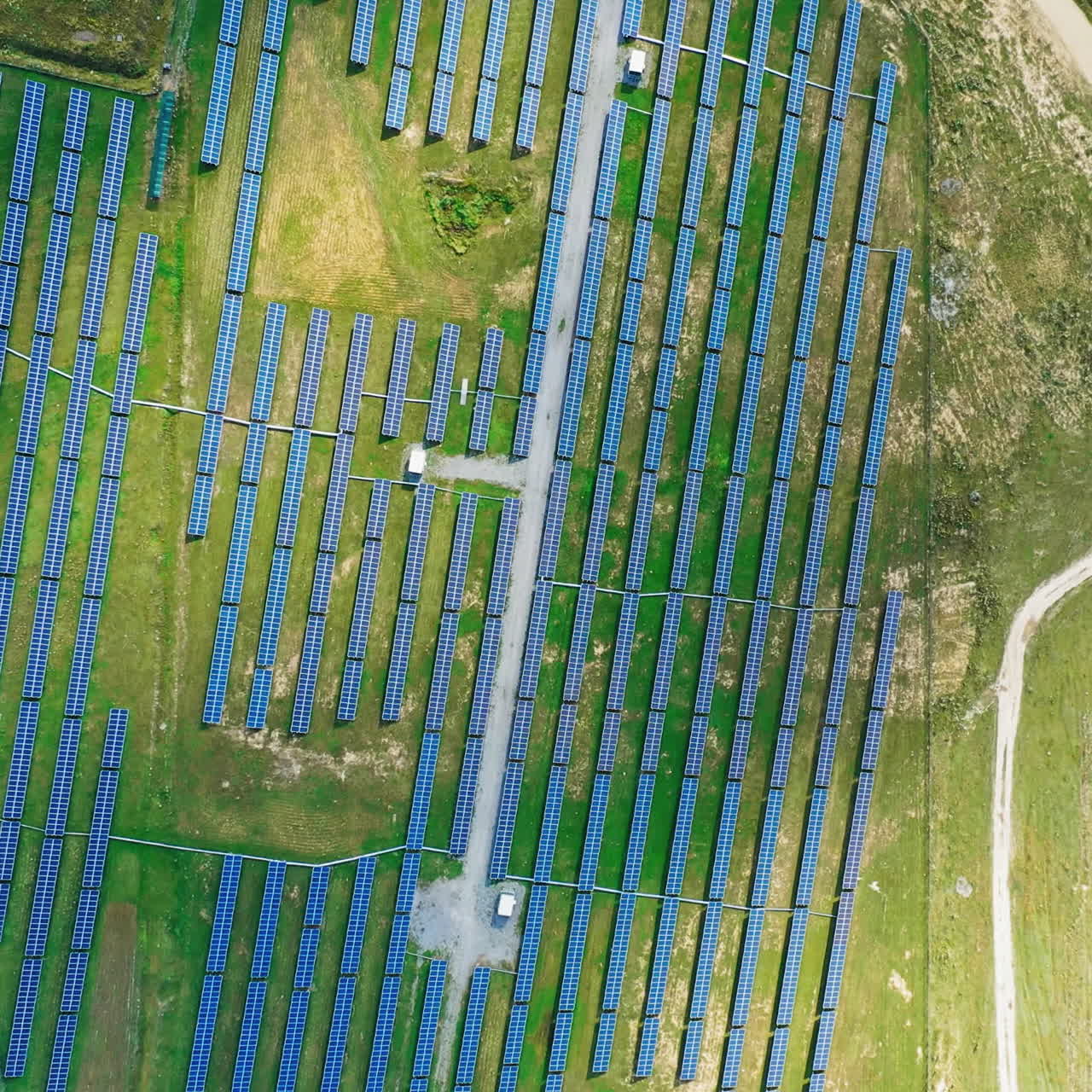Rows of solar panels on the field. View from above on a modern renewable energy farm in the rural place. Aerial view. Camera moves around.