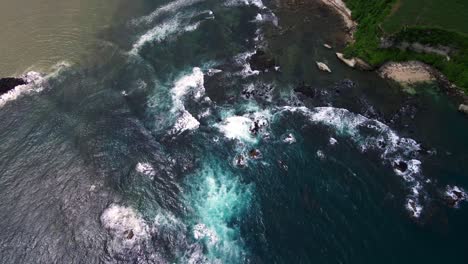 Luftaufnahme-Von-Hohen-Wellen,-Die-An-Den-Felsen-Nahe-Der-Klippe-Der-Indonesischen-Insel-Sumbawa-Brechen