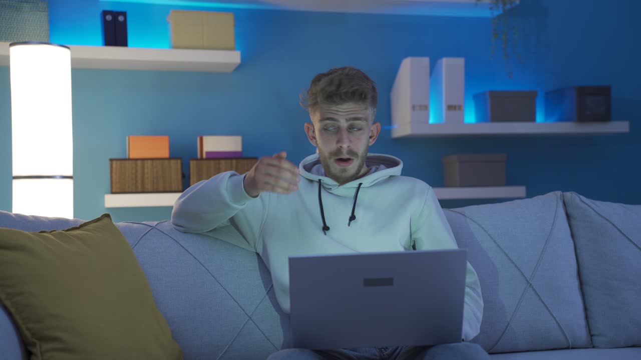 el joven que usa la computadora portátil está sorprendido, sorprendido por las noticias, el mensaje.