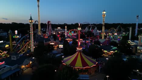 bright lights illuminate the amusement park as the sun sets on a lively summer evening. visitors enjoy thrilling rides, games, and colorful attractions in a vibrant atmosphere.