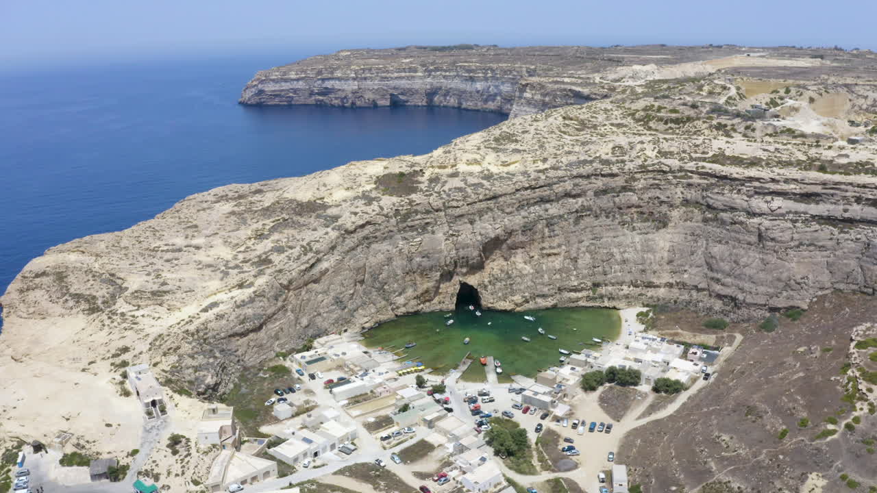 ciudad portuaria de la cueva de dwerja escondida detrás de la pared rocosa del acantilado, malta, antena
