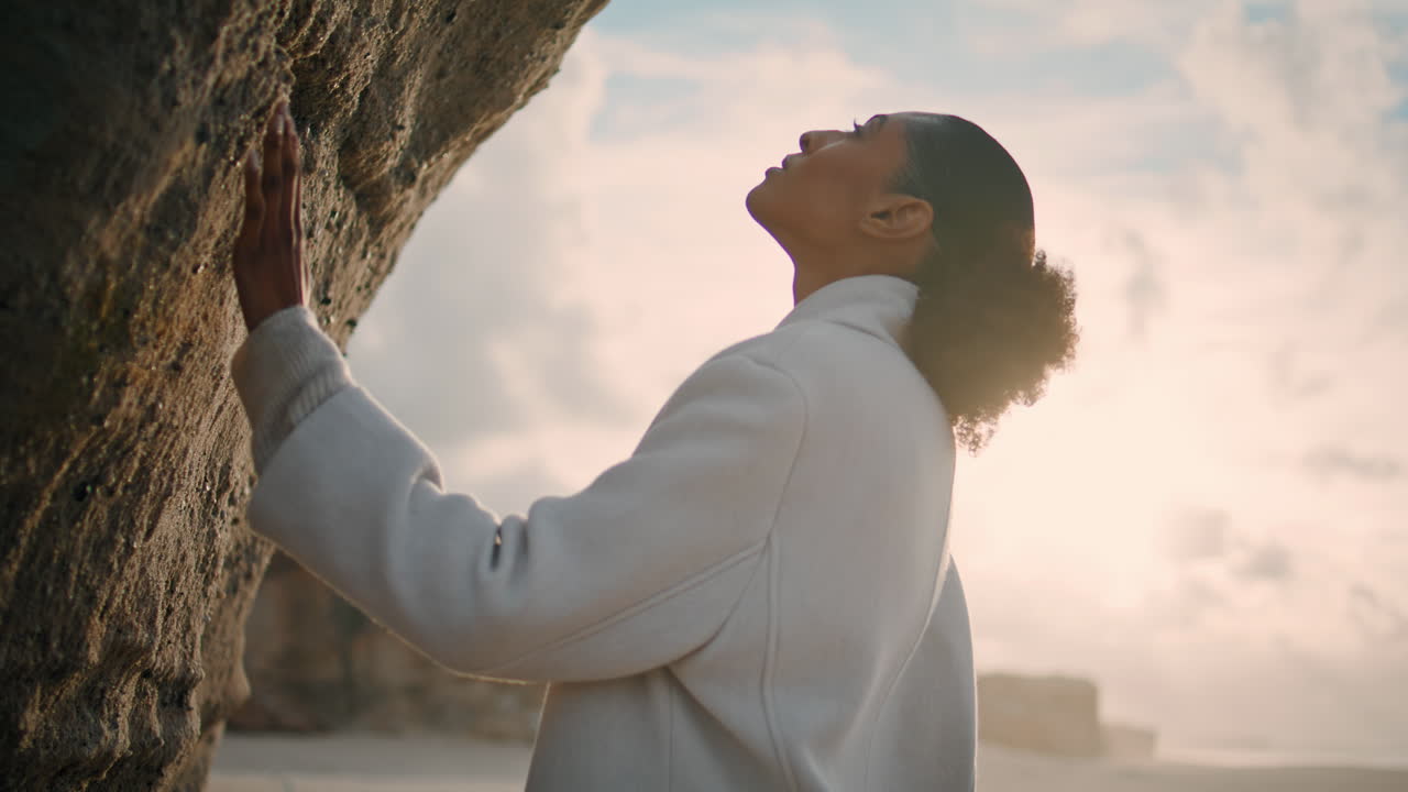 una mujer solitaria admirando la naturaleza tocando el acantilado del océano.