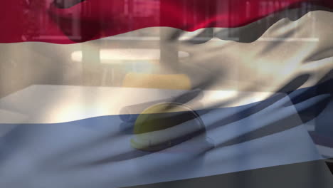 animation of netherlands flag over yellow helmet and floor plan on table against glass window