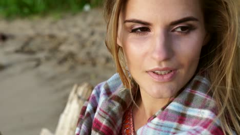frau in geradeltem schal am strand
