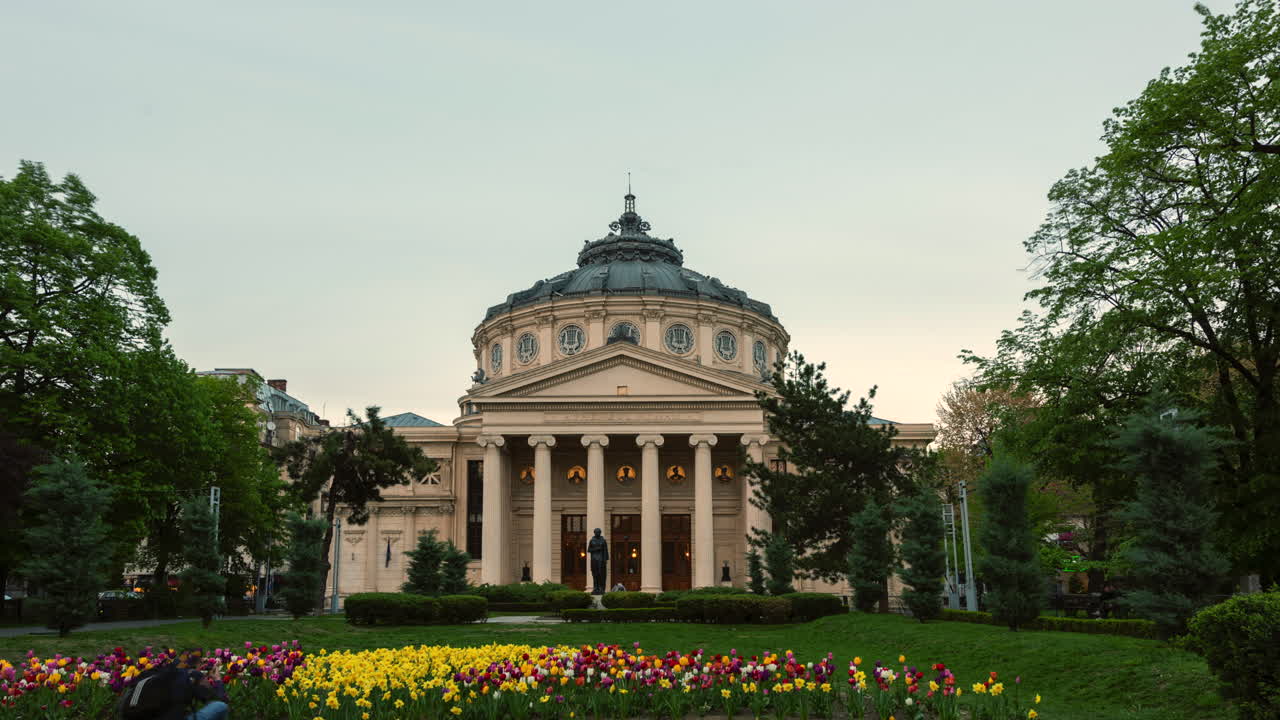 Time lapse of the beautiful view of the Romanian Athenaeum, a neoclassical concert hall in Bucharest, surrounded by gardens and flowers