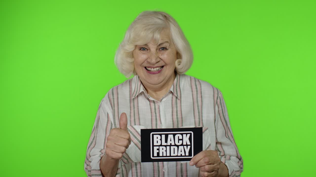 Anziana nonna mostra un biglietto con la scritta Black Friday, sorridendo e apparendo soddisfatta dei prezzi bassi