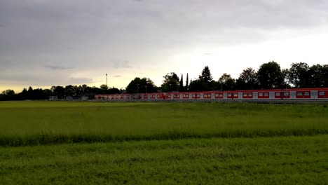 Drone-tracks-commuter-train-on-rural-stop-near-Munich