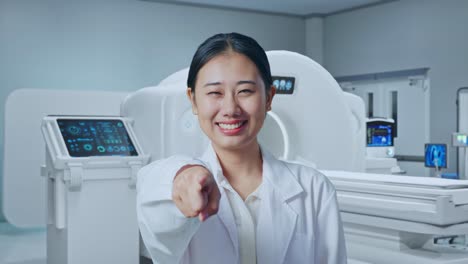 close up of asian woman doctor making honest gesture and smiling with mri machine in the hospital