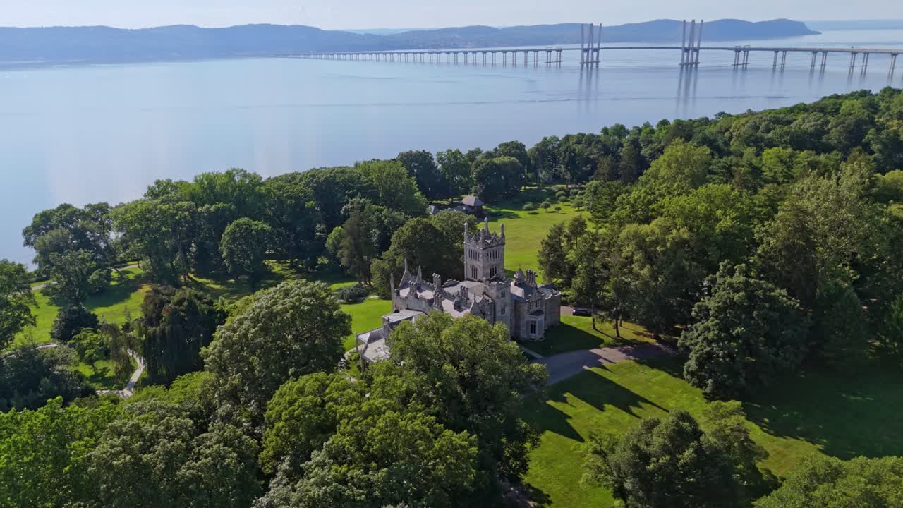 Luxury historic castle mansion in Lyndhurst, New York. Aerial top down shot. Sunny day in summer. Hudson River and bridge in background. Luxury property home