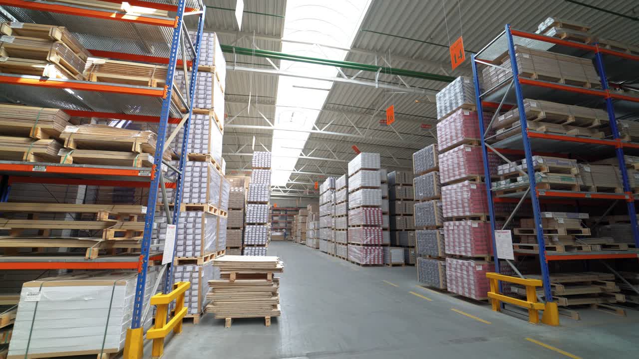 Shelves of warehouse are filled with parquet. Stock of woodworking factory. Camera motion to around