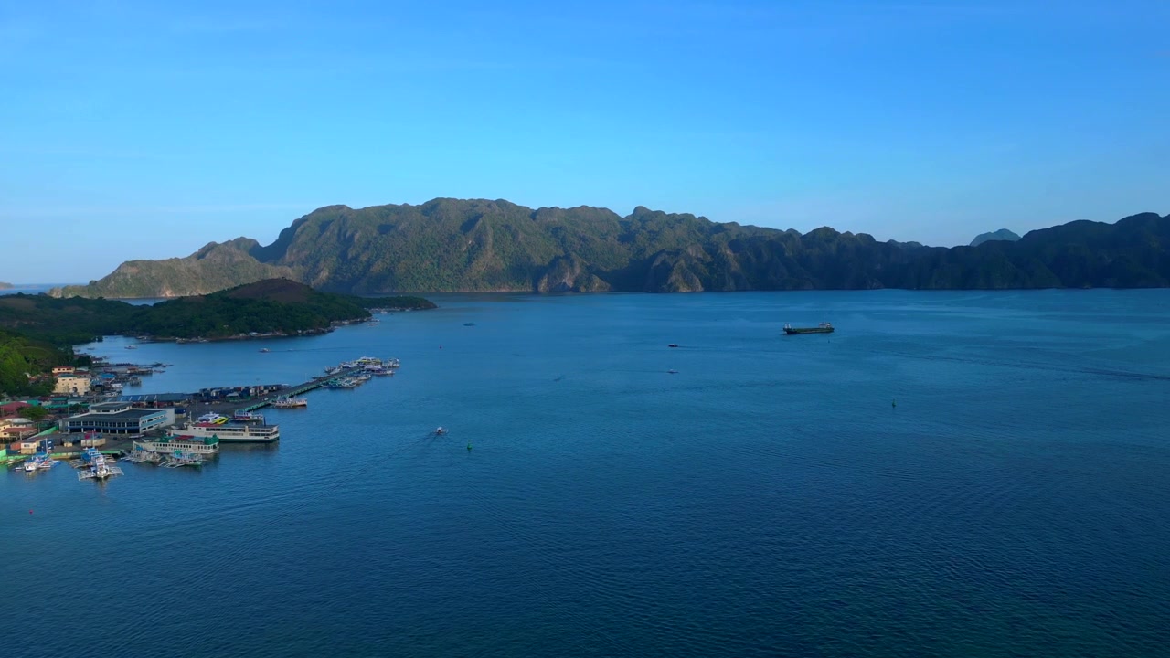 Paisaje sereno desde arriba mostrando barcos en las aguas cristalinas de la Bahía de Coron, Palawan, rodeado de exuberantes islas tropicales. Excelente vista aérea, panorama estático de dron en vuelo estacionario.