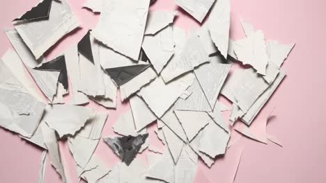 top-down video angle of torn paper collage on a beige background, showcasing a textured, abstract