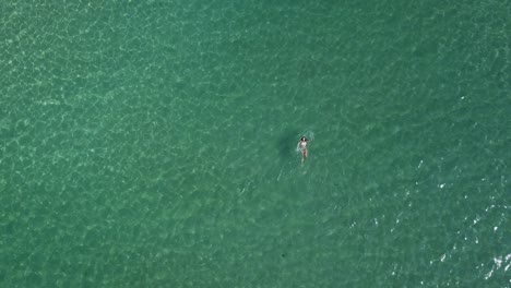 Female-tourist-swims-on-her-back-in-the-clear,-shimmering,-green-waters-of-the-Aegean-Sea