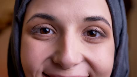 closdeup portrait of young muslim female in gray hijab with brown eyes looking straight at camera