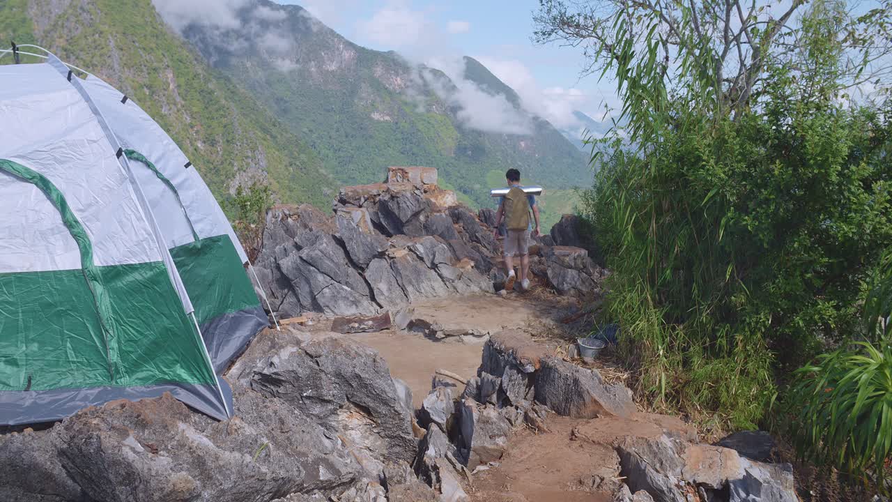 excursionista asiático hombre excursionando a la cima de la montaña nebulosa acampando en la montaña