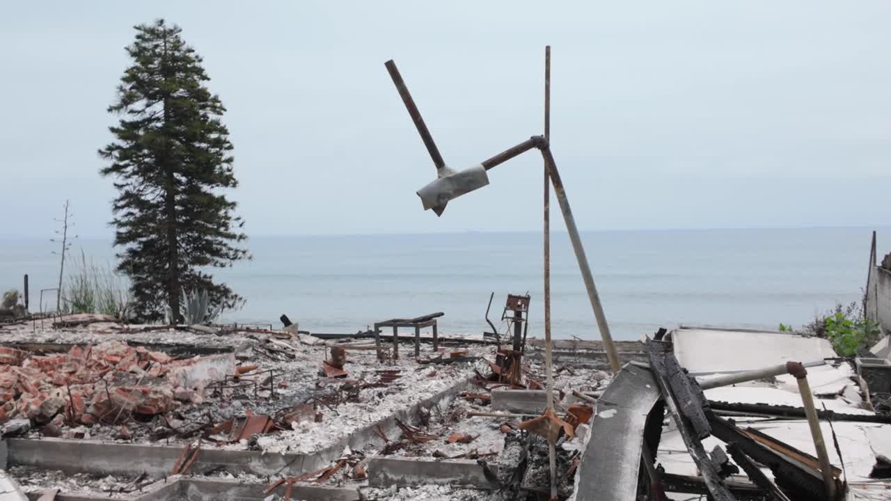 Gimbal close-up panning shot of a burned ocean view property after the Palisades wildfire in Malibu, California. 4K
