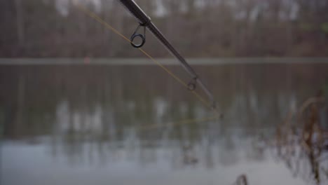 pov fishing adventure: reeling in carbon rod at lakeside