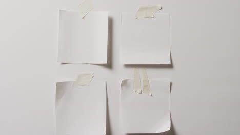 video de un primer plano de cuatro notas blancas con espacio de copia pegado a un fondo blanco