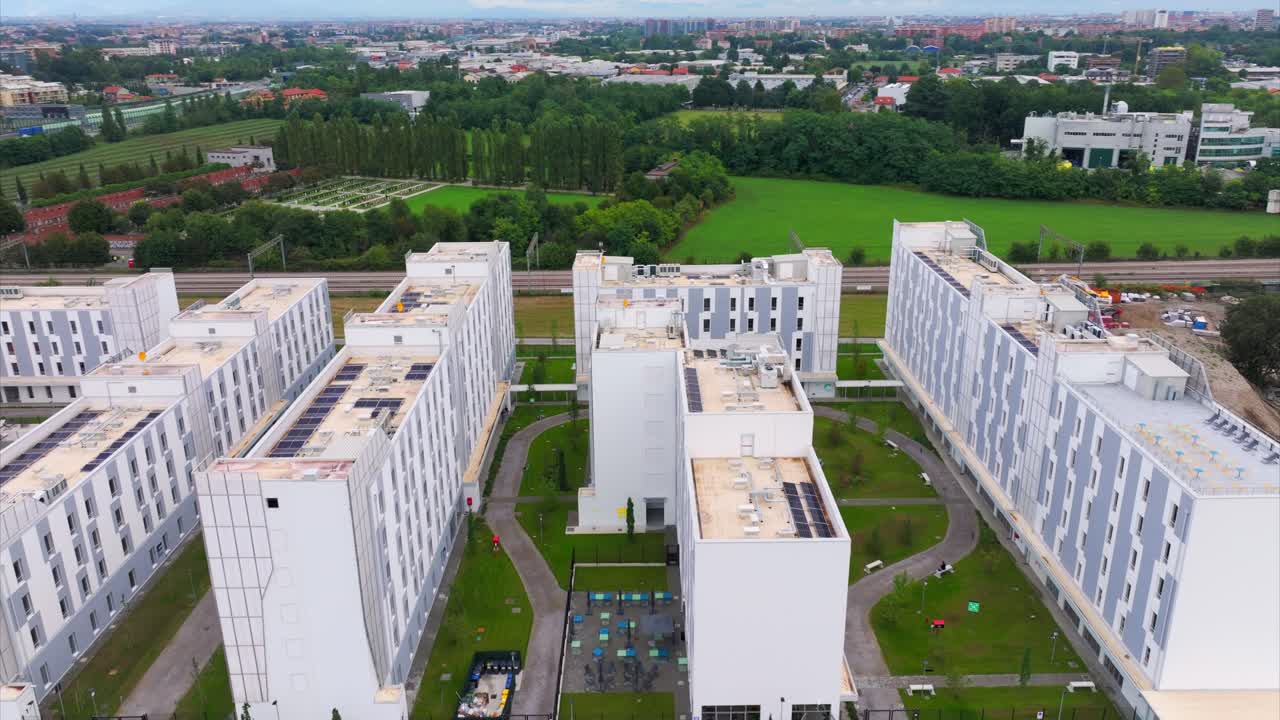 Student Campus X or CX Milan with train passing in background, Novate Milanese, Italy. Aerial drone view
