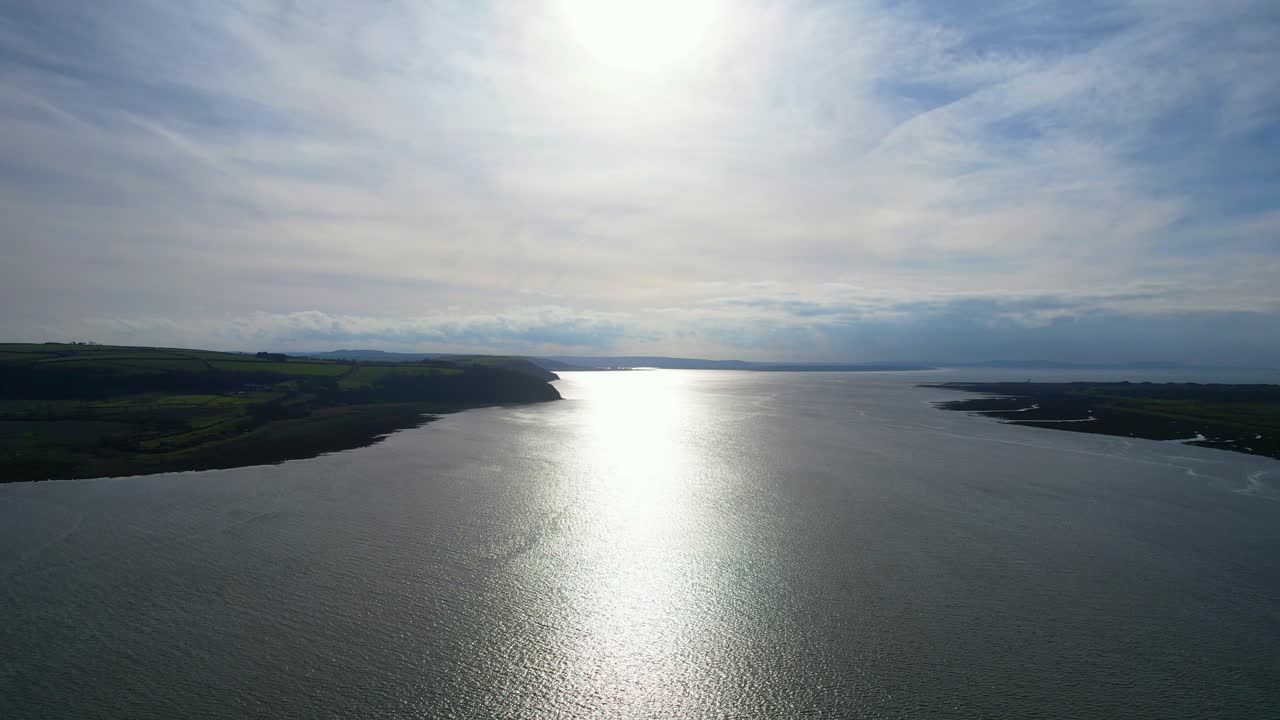 웨일즈의 카마르텐셔에 있는 카마르덴 만 근처의 코란 강에서 아침 태양 반사