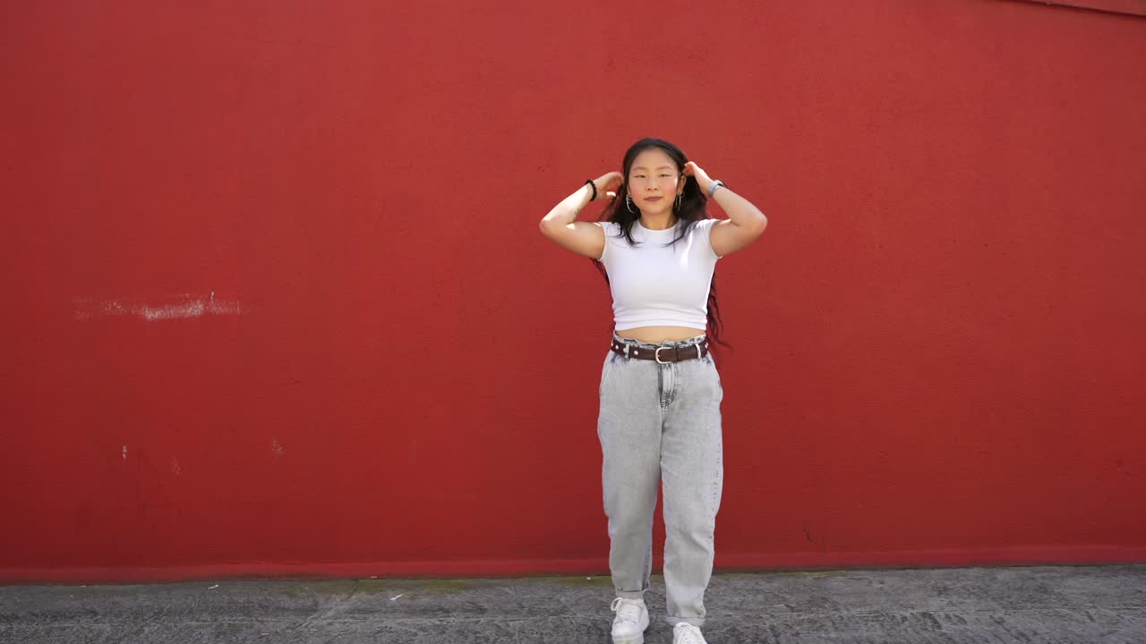 Donna che balla davanti a un muro rosso