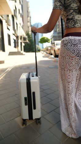 woman with luggage on city street