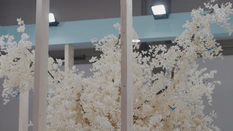 Ethereal-white-artificial-tree,-enhanced-with-delicate-blossoms,-creating-an-enchanting-indoor-forest-ambiance