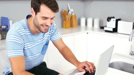 hombre guapo usando portátil y teléfono inteligente