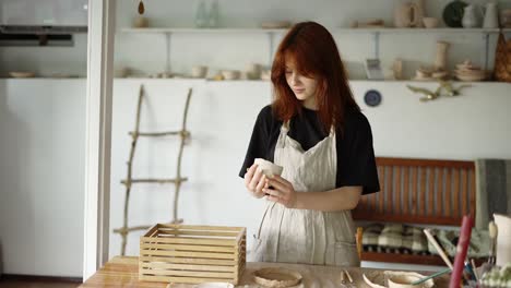 red-haired potter girl puts her products in a wooden box