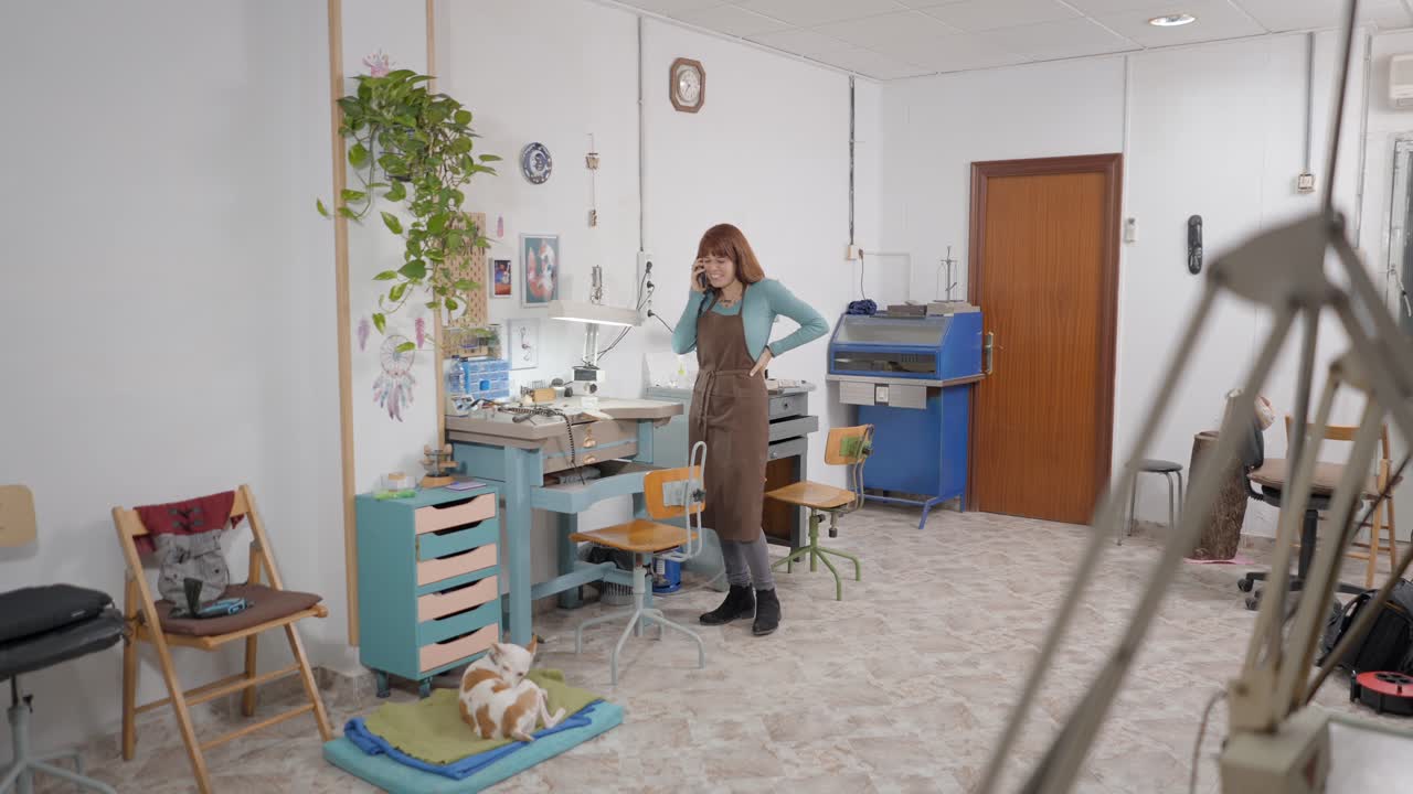 Jeweler Talking on Phone in Workshop